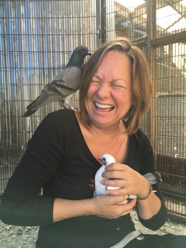 Laughing person with pigeon on her shoulder