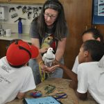 MickaCoo director introducing pigeon to animal shelter summer campers