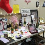 A table of donated silent auction items at Holiday Party